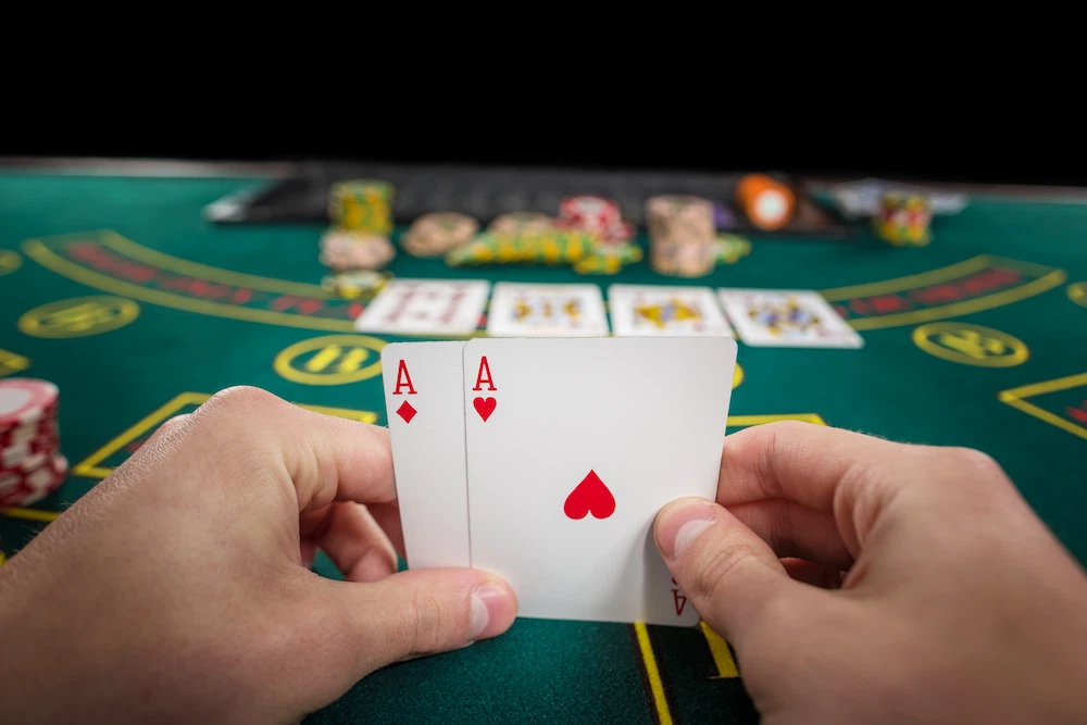Player on a blackjack table looking at his hand of two aces